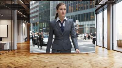 A woman in a business suit walks down a busy city street Wall mural