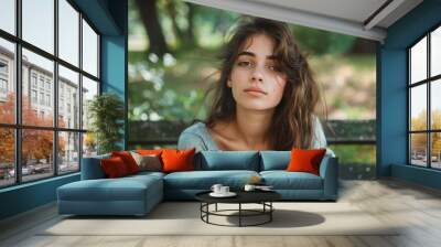 A woman with long brown hair is sitting on a bench Wall mural