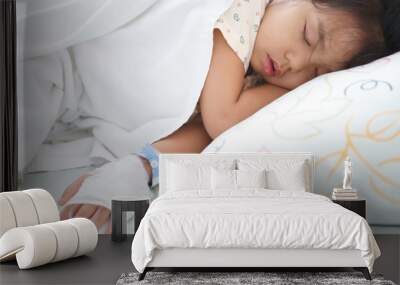 Asian child or kid girl patients sleep rest on bed or sick and headache with feverish in pediatric hospital with salt water saline on hand for treatment healthcare in hospital for infusion a disease Wall mural