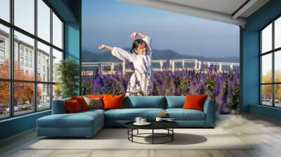 Asian child or kid girl relax on beauty of many fresh flowers to happy smile on blue violet in nature flower field garden on holiday travel and mountain white bridge sky view at Yingyong flower garden Wall mural