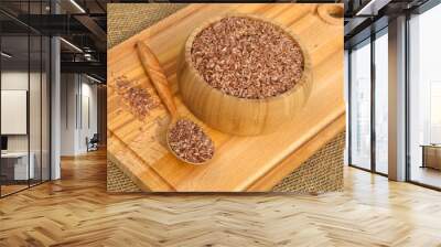 Uzbek devzira, the red rice in a bamboo bowl and a wooden spoon on a cutting Board Wall mural