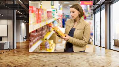 Woman checking food labelling Wall mural