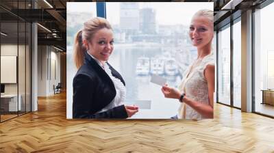 two young and beautiful business woman with business card Wall mural