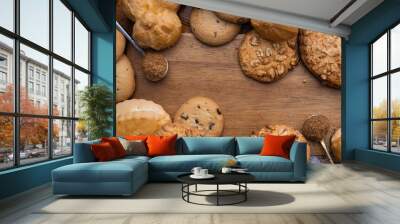 different sweet pastries on a wooden board. Cookies, bun, muffins, tartlets, cupcakes and eclairs
 Wall mural