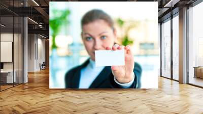 A smiling girl in costume shows a blank business card Wall mural