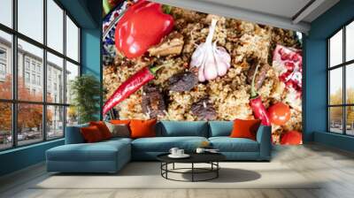 freshly prepared delicious pilaf on a colorful dish decorated with vegetables. View from above. Wall mural