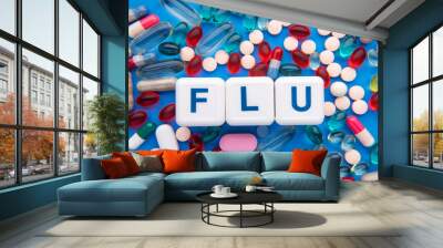 On the blue table colorful pill and cubes with the inscription - FLU. medicine concept. Wall mural