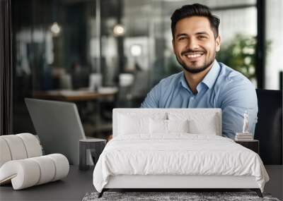 Smiling businessman working on laptop in office Wall mural