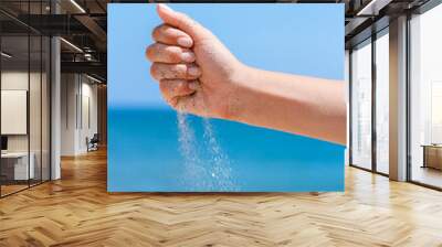 A Hands pour sand off the sea on nature on a journey. Vacations at sea sand time passes. Wall mural