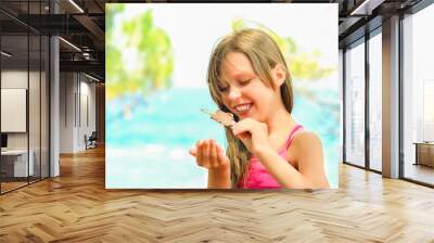 A Happy child girl with ice cream by the sea in nature in the park journey Wall mural