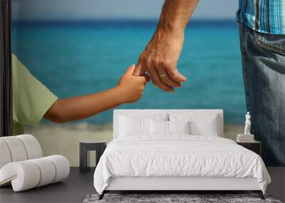 The parent holds the child's hand on the beach Wall mural