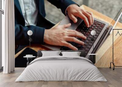 Close up of unrecognizable businessman working on laptop in coffee shop working space Wall mural