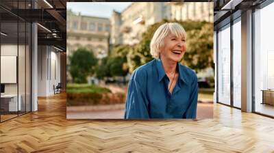 Don't stop laughing! Beautiful senior woman in casual wear smiling and feeling happy while standing outdoors on a sunny day Wall mural