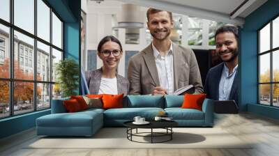 Group of happy, motivated business people standing together at office with their leader Wall mural