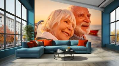 In love. Close up portrait of a beautiful and happy senior couple hugging, relaxing and smiling while sailing together in the sea at sunset Wall mural