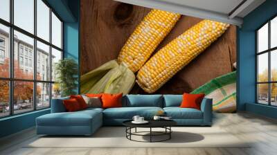 Two cobs sweet corn on wooden background.. Wall mural