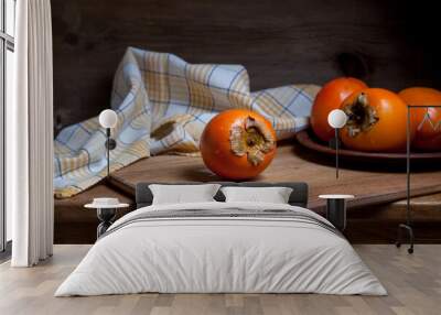 Whole ripe persimmon on a wooden background.. Wall mural