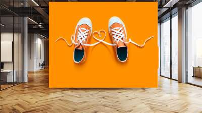 Short low  bright sneakers on a orange background. Wall mural