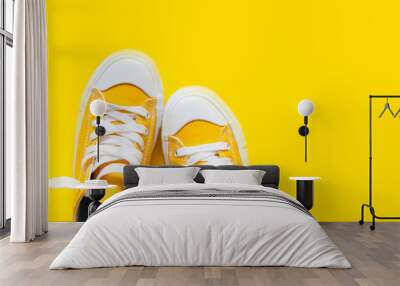 Short low  bright sneakers on a yellow background. Wall mural