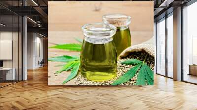 Oil hemp in two jars with sheet on wooden board Wall mural