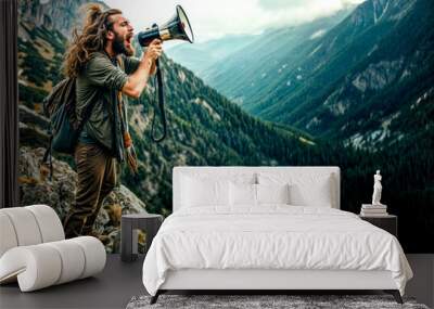 Man standing on top of mountain with megaphone in his hand. Wall mural