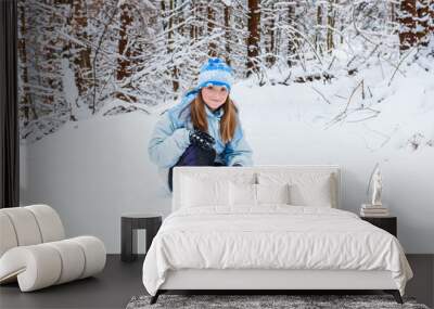 girl enjoying day playing in winter forest Wall mural