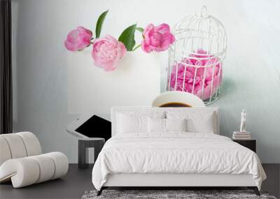 Small bird cage with peony flower bouquet, invitation card template with text space, smarphone device with black screen, small aroma coffee cup. Greeting card and white provence interior. Wall mural