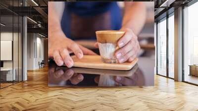 The coffee shop startup owner serving a cup of coffee at the coffee counter Wall mural