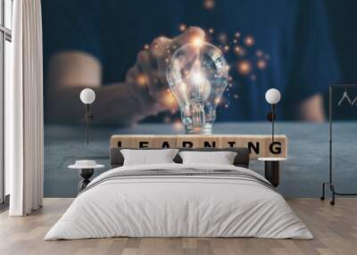 Glowing light bulb with cube letter word of LEARNING. Self learning or education knowledge and business studying concept. Idea of learning online class or e-learning at home. Wall mural