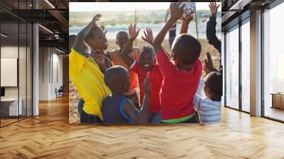 Boys playing soccer together in dirt field Wall mural