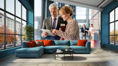 Business people using digital tablet in airport Wall mural