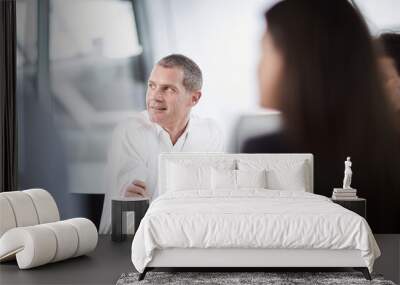 Businessman listening looking away in meeting Wall mural