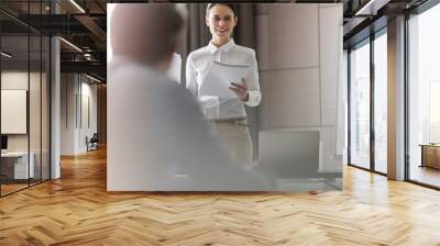 Businesswoman with paperwork leading meeting in conference room Wall mural