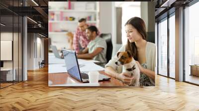 Dog sitting on woman lap in office Wall mural