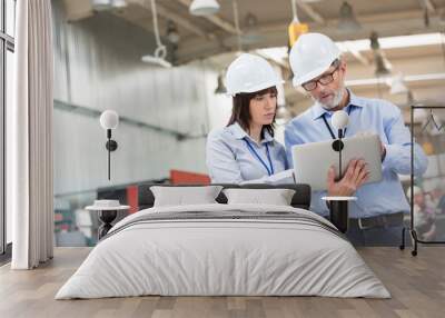 Engineers with laptop in factory Wall mural