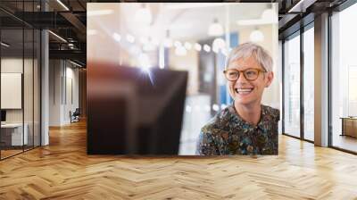 Enthusiastic senior businesswoman looking away in office Wall mural