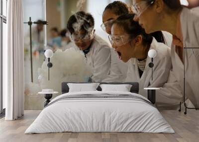 Female teacher and students watching scientific experiment chemical reaction in laboratory classroom Wall mural