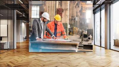 Manager and steel worker engineer reviewing blueprints in factory Wall mural