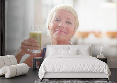 Older woman drinking juice on exercise mat Wall mural