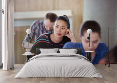 Pensive female college student taking test in classroom Wall mural