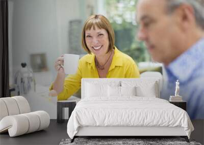 Portrait smiling mature woman drinking coffee at breakfast table Wall mural