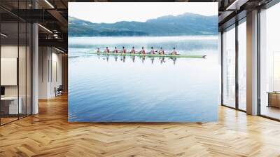 Rowing team rowing scull on lake Wall mural