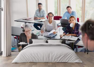 Smiling students watching teacher in adult education classroom Wall mural