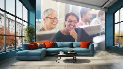 Smiling women at computer in adult education classroom Wall mural