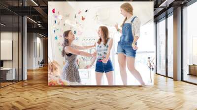 Three teenage girls dancing on bed in bedroom Wall mural