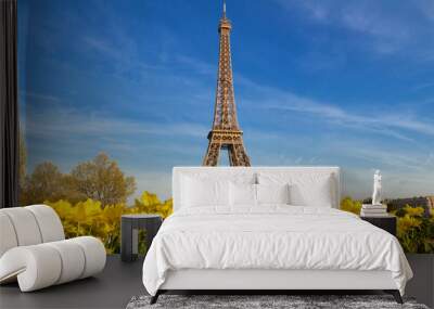 The Eiffel tower with a vibrant blue spring sky with yellow flowers in foreground, Paris, France. Wall mural