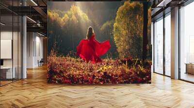 Beautiful brunette girl in a chic red dress posing in the fairy autumn forest. Wall mural