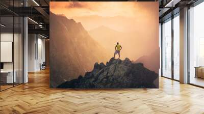 Man on the top of the hill watching wonderful scenery in mountains during summer colorful sunset in High Tatras in Slovakia. Travel, adventure or expedition concept.. Wall mural