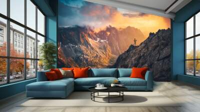 Man on the top of the hill watching wonderful scenery in mountains during summer colorful sunset in High Tatras in Slovakia.. Wall mural