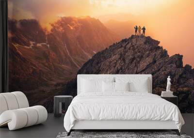 Together overcoming obstacles as a group of three people raising hands up on the top of a mountain. Celebrate victory and success over sunset background. Goal achievement symbol.. Wall mural